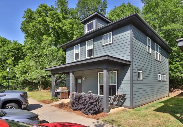 Modern townhome with porch swing grill and trees exterior at Varsity Club in Clemson Student Accommodation